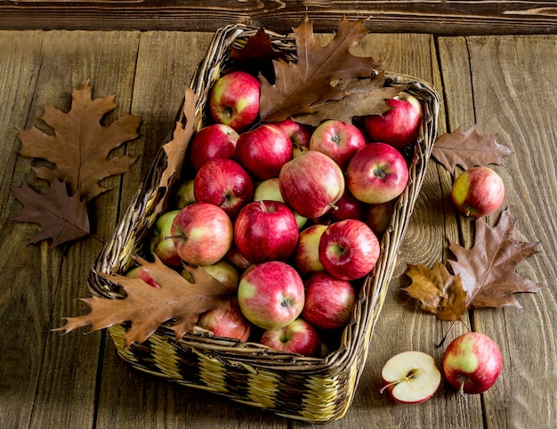 Wicker basket with apples on a wooden table