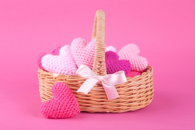 Wicker basket with multi-colored knitted hearts