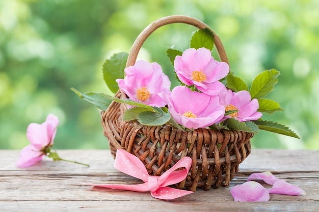 Wicker basket with wild rose flowers Wedding or birthday decoration