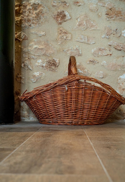 Wicker basket on a wooden floor in front of a stone wall