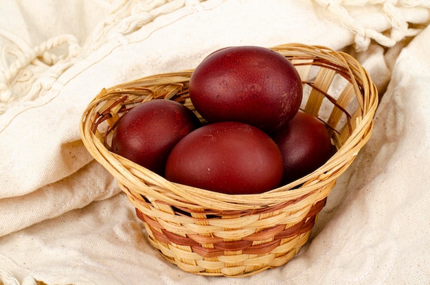 Wicker bowl with red hand-painted easter eggs. Studio Photo