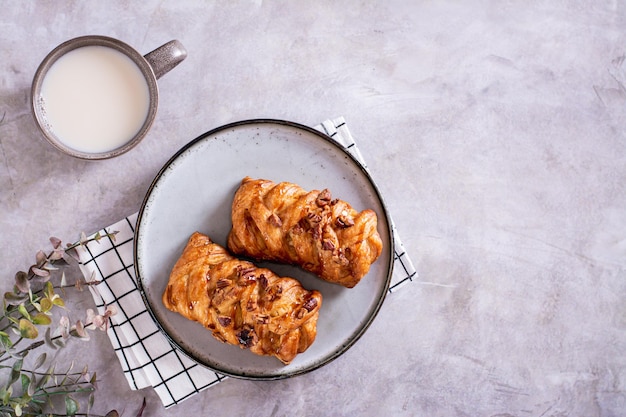 Wicker buns with cinnamon nuts and maple syrup and a cup of coffee for Swedish fika time top view