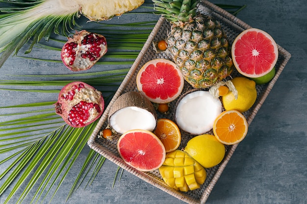 Wicker tray with various delicious fruits on grey table