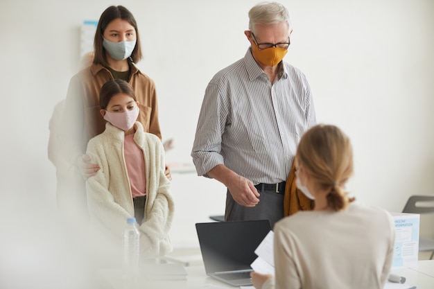 Wide angle portrait of modern senior man registering for covid vaccine in medical clinic, copy space