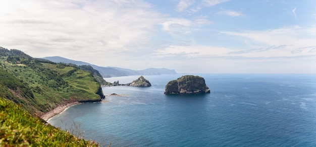 Wide panorama of emerald green cape cabo Machichaco of Basque coast Spain