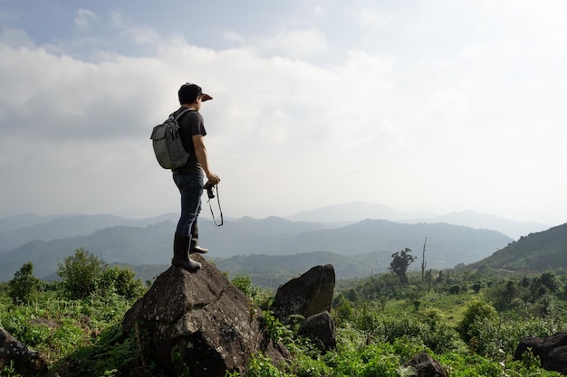 A wide shot of sian man with his backpack and camera is travel alone