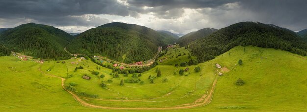 Wideangle panoramic shot of beautiful meadows hills and trees in Synevyrska glade next to Synevyr lake Majestic and wonderful landscapes of the Carpathian mountains in Ukraine