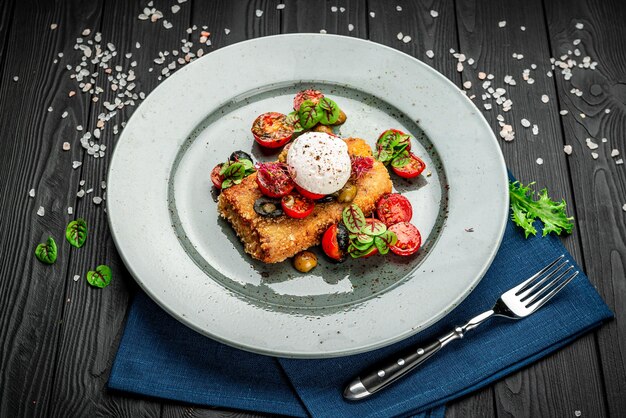 Wiener schnitzel with poached egg olives and tomatoes