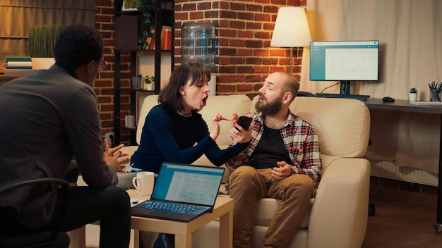 Wife having proof that husband cheated on smartphone, showing text messages and being caught with adultery. Unhappy woman dealing with infidelity at counseling session with therapist.