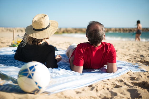 Wife and husband lying at beach