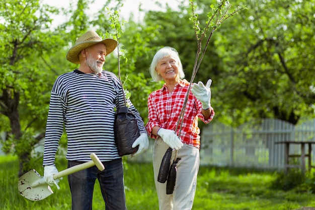 Wife smiling. Loving wife smiling while planting trees together with husband near their cottage husband