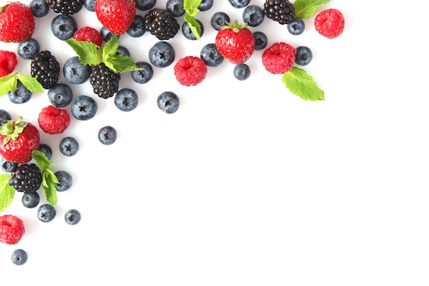 Wild berries and mint leaves on a white background top view