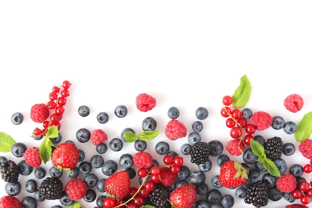 Wild berries and mint leaves on a white background top view