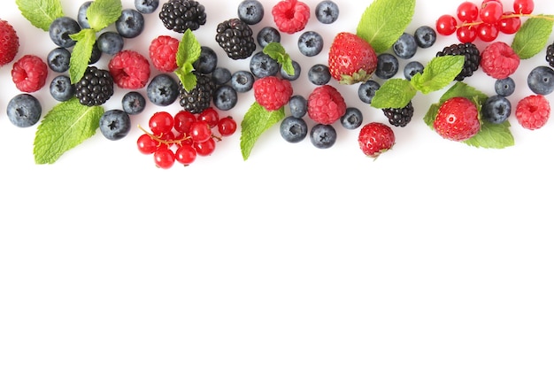 Wild berries and mint leaves on a white background top view