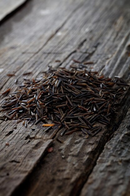 Wild brown rice on wooden surface