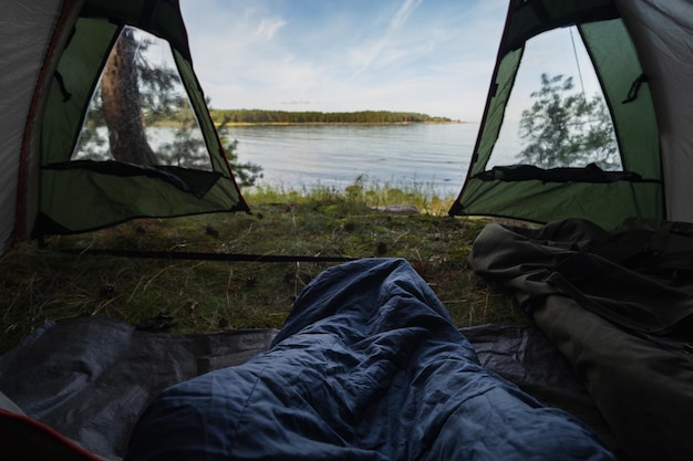 Wild camping in nature Aegna island on a summer morning View from a tent on the seashore sleeping ba