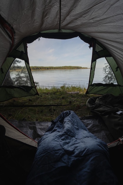 Photo wild camping in nature aegna island on a summer morning view from a tent on the seashore sleeping