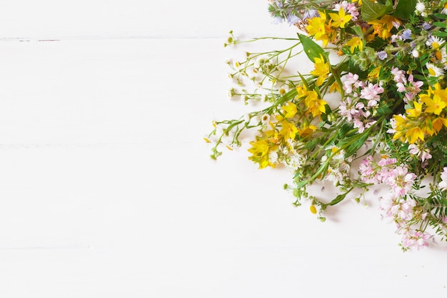 Wild flowers with straw hat on white