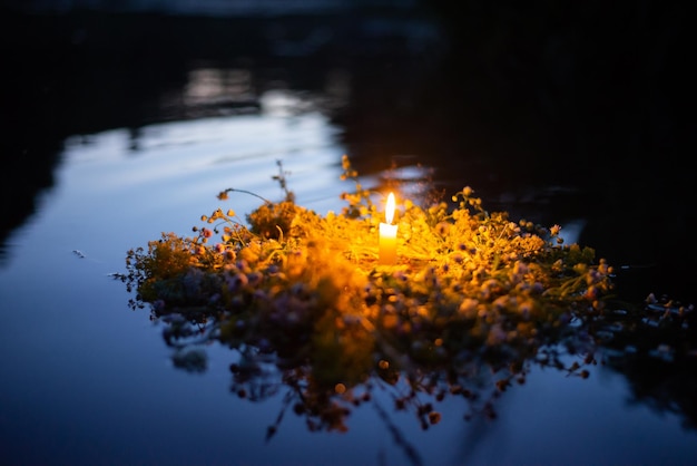 Wildflower wreath with a candle floating on the river Ivan Kupala Kupala traditions