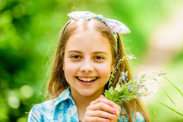 Wildflowers Spring holiday Womens day Natural beauty Childhood happiness happy child hold wildflowers summer Green environment little girl and flower bouquet Staying beautiful any season