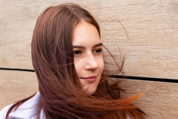 Wind blowing young woman long brown hair