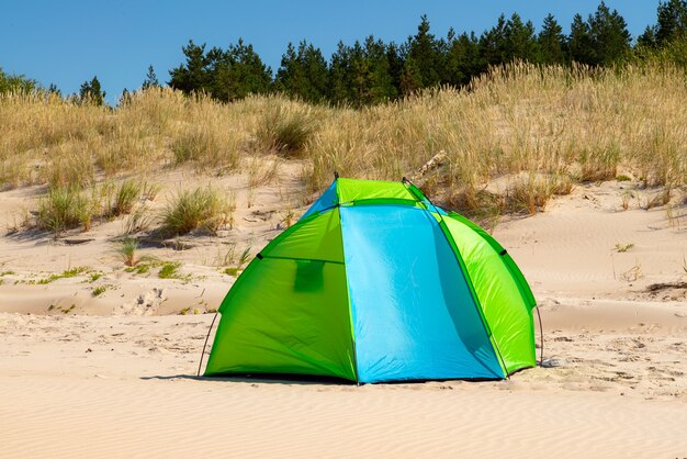 Wind breaker tent on a sandy beach by the sea.