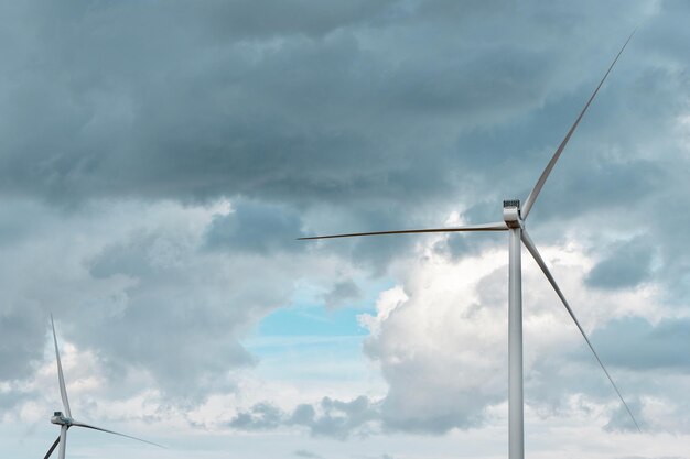 Wind energy generators on the field under stormy dramatic sky Horizontal background