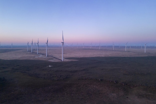 A wind farm in the desert with a pink sky Sunrise in Oregon