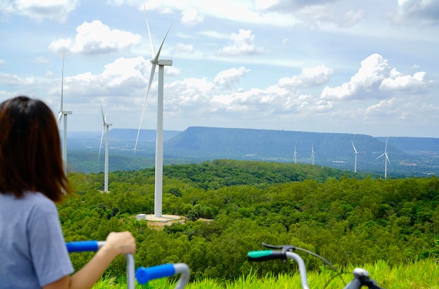 Wind farm with woman riding bike in foreground Wind energy Wind power Sustainable renewable energy