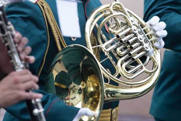 A wind instrument parade a man in green costume playing french horn