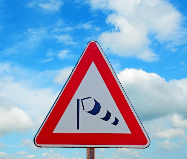 Wind sock sign under a blue sky with clouds