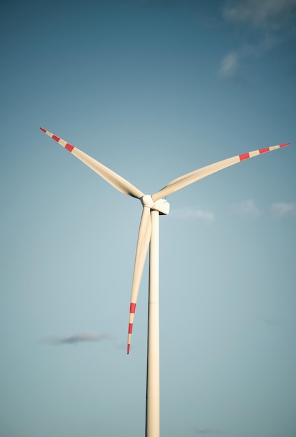 Wind turbine against blue sky in the evening sun Vertical photo