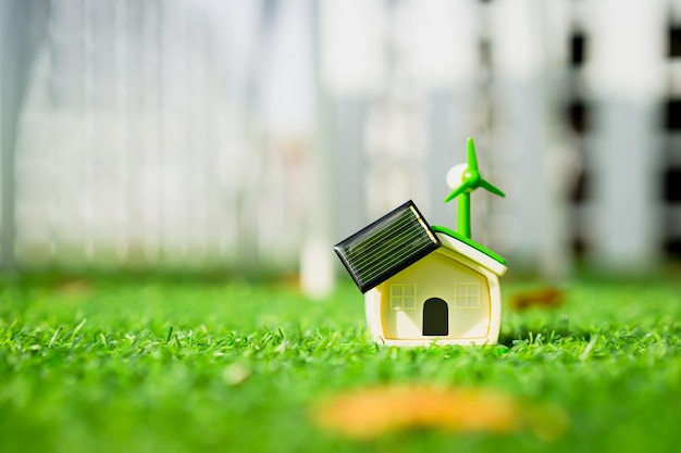 Wind turbine house model with solar energy on green grass