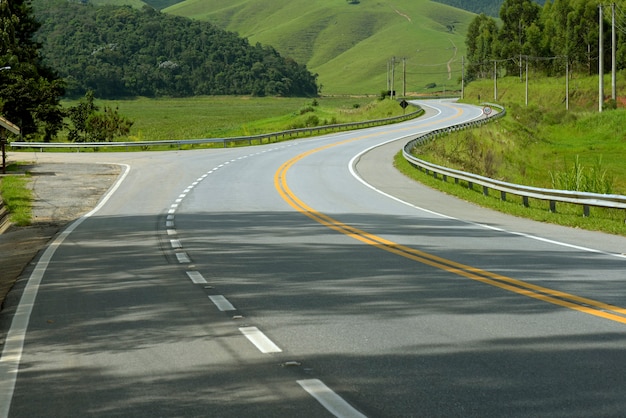 Winding highway with green fields on the horizon