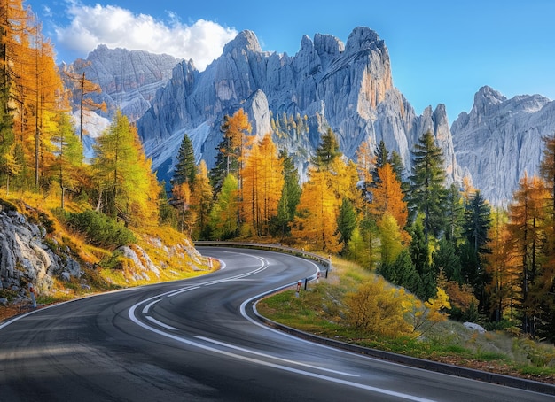 A winding paved road in an autumn forest against the background of mountains A beautiful natural