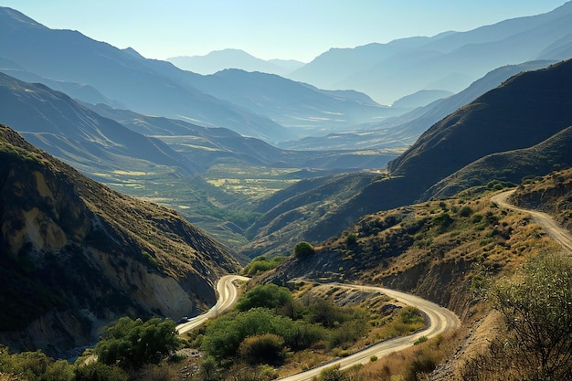 Photo a winding road in the mountains with a view of a valley and a valley in the distance