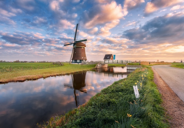 Photo windmill near the water canal at sunrise in netherlands