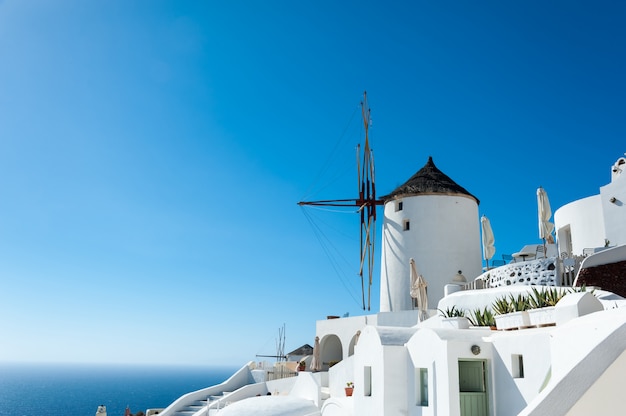 Windmill in Oia with blue sky and sea in Santorini island