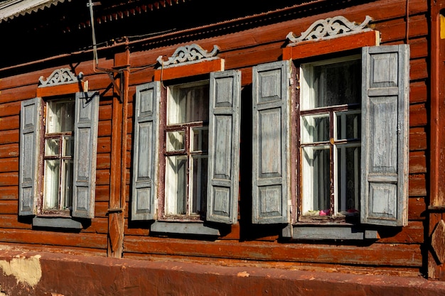 Windows of an old vintage wooden house in the afternoon on a sunny day. Architecture of the provincial city of Ukraine. Soviet Union age building USSR