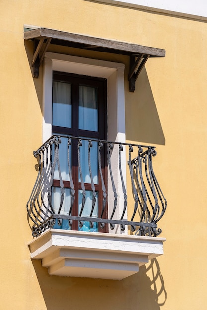 Windows with balcony on building facade with cast iron ornaments in Bodrum, Turkey