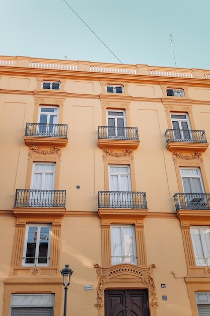 Windows with shutters and small balconies outside on the building facade downtown Barcelona Spain