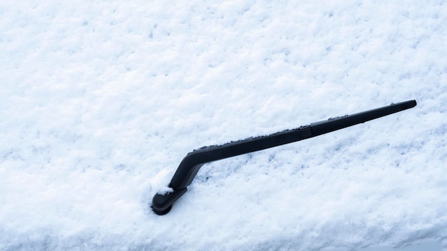 windshield wiper on snow-covered car window