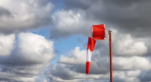 Windsock at an airport with a cloudy sunny sky in background