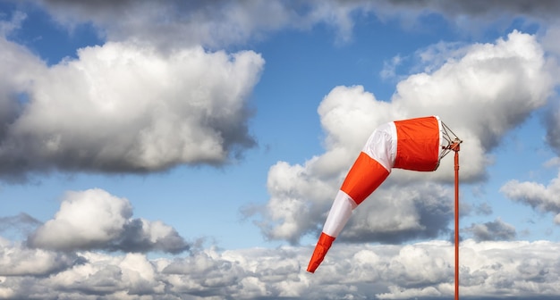 Windsock at an airport with a cloudy sunny sky in background