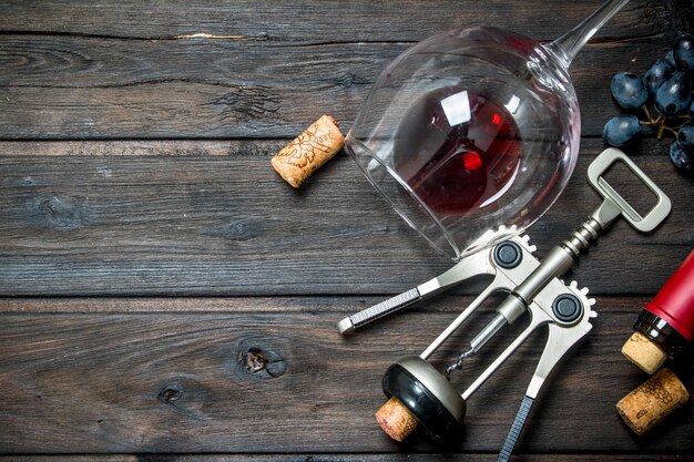 Wine background A glass of red wine with grapes and a corkscrew