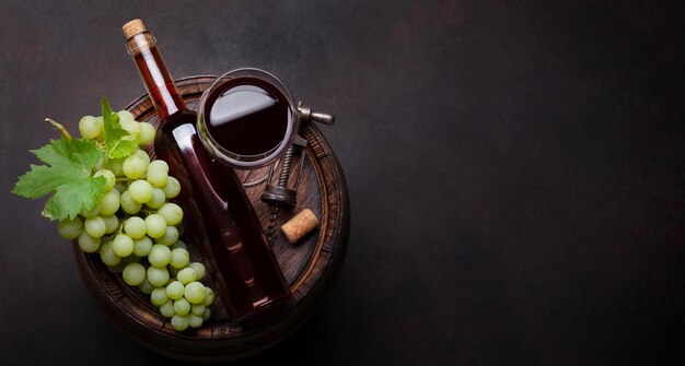 Wine bottle and white grape on old barrel