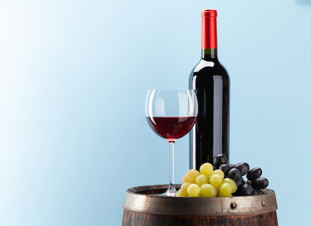 Wine bottle with red wine and old wooden barrel