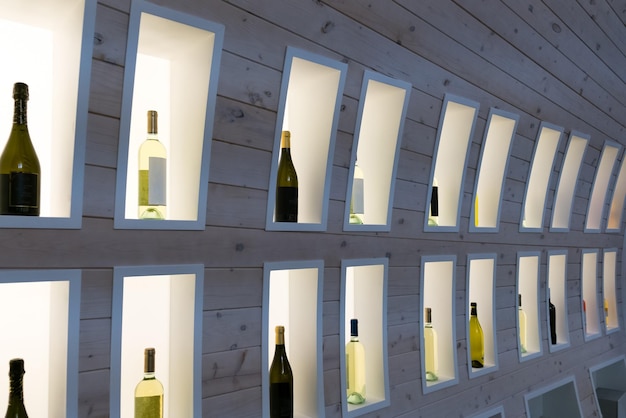 Wine bottles on wooden shelf in wine store champagne in a wooden display case