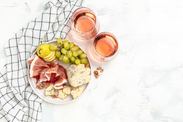 Wine and cheese still life wine and assorted Cheese Plate with fruit Grapes Pear Nuts Cashew Cheese with mold Gorgonzola A glass of wine with cheese