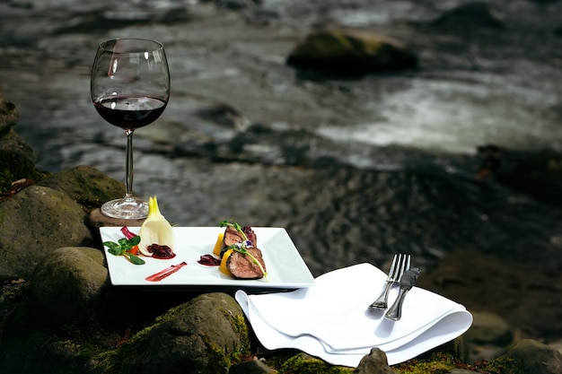 Wine glass and meal near water